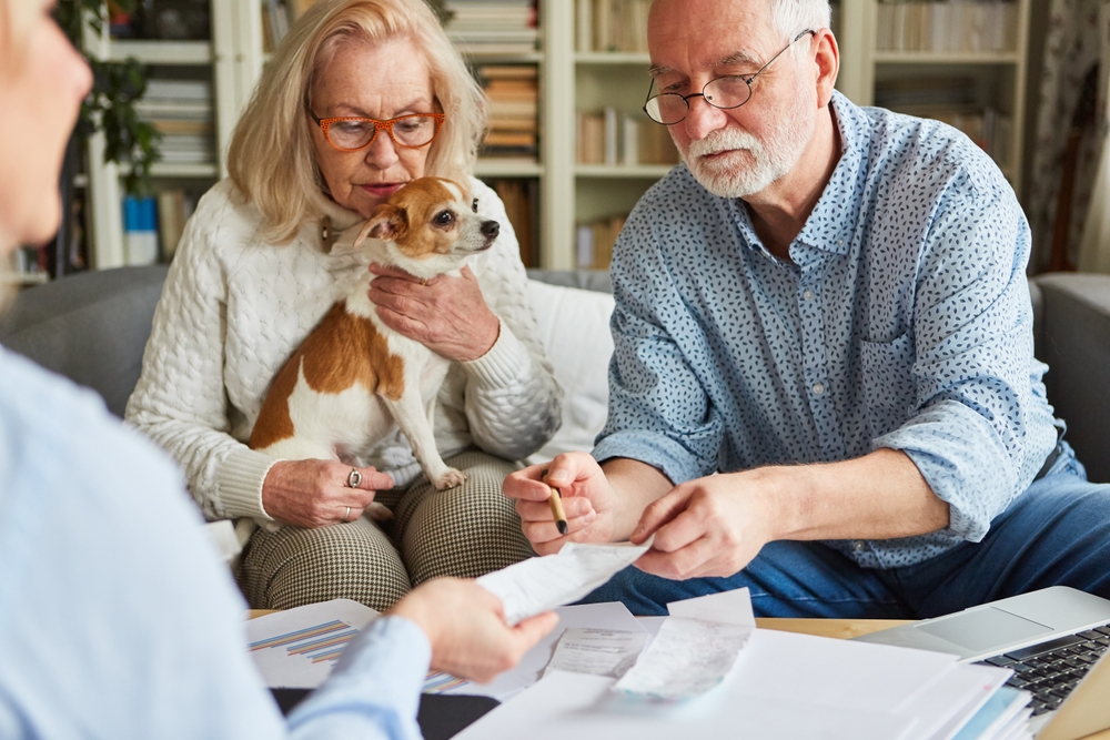Senior couple reviewing paperwork to understand pet insurance coverage options
